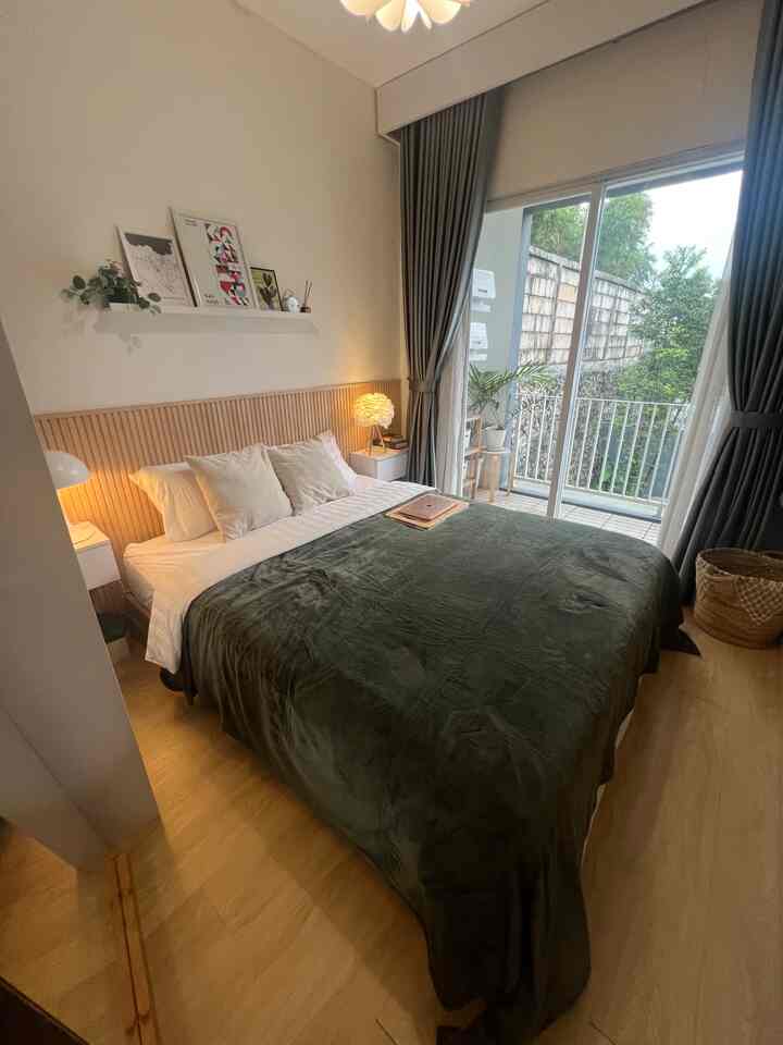 White and green toned small Scandinavian bedroom featuring large window and balcony creating a sense of openness
