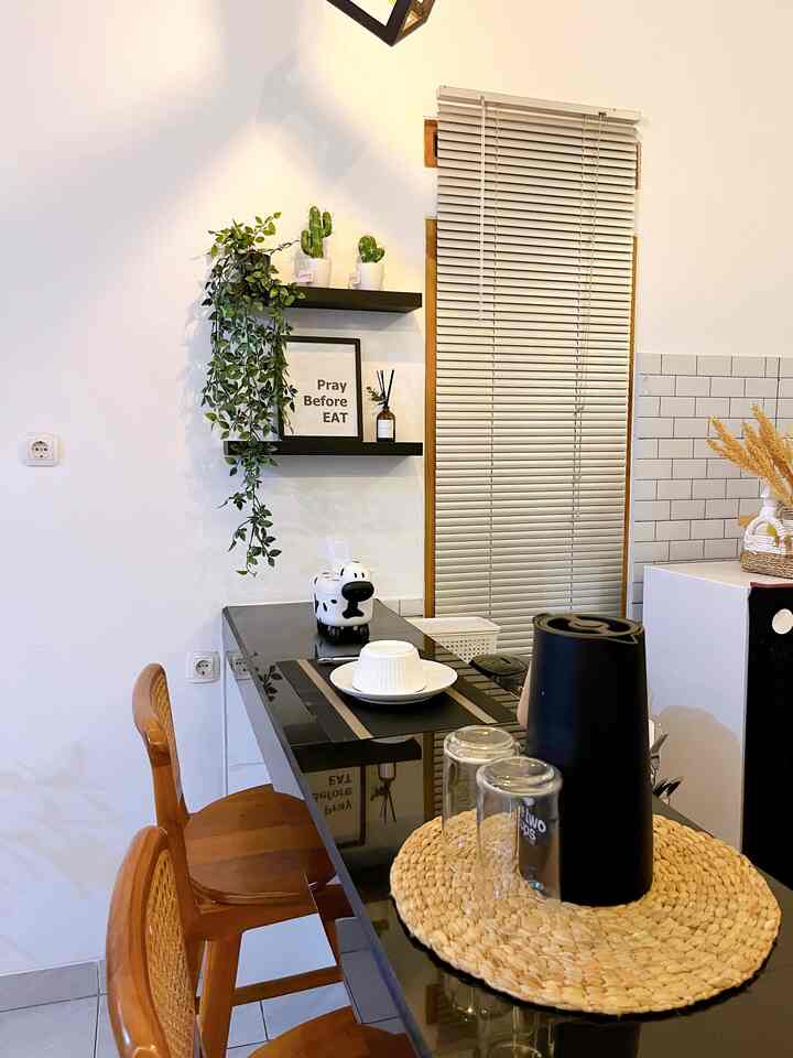 White and brown toned kitchen featuring blinds, plants, and a natural home cafe atmosphere