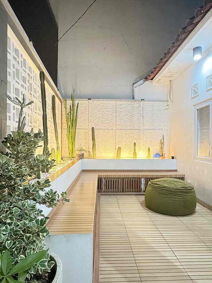 Natural-toned terrace with wood tones and beige walls, featuring multiple plants and a green bean bag creating a relaxing atmosphere