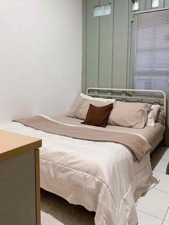Beige and white toned bedroom featuring simple modern furniture and tidy bedding in a cozy space