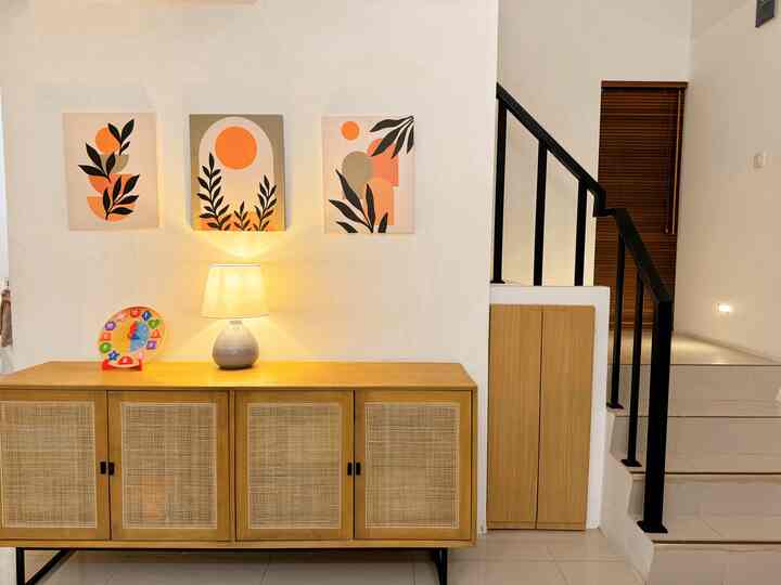 Natural wood tone credenza and white walls highlight functional under-stair storage ideas in a modern interior space