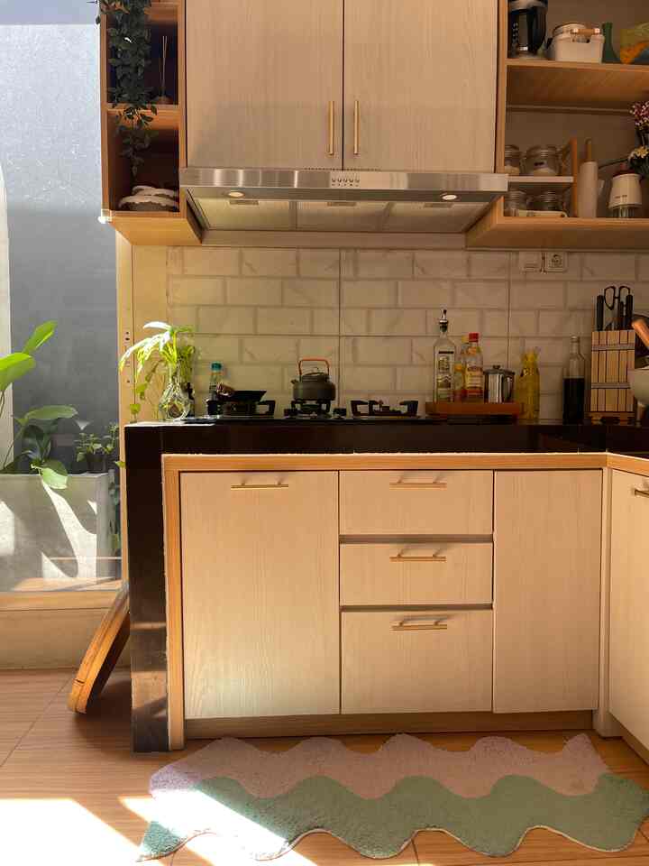 Natural-toned kitchen space featuring wooden cabinets and plants, creating a warm and cozy atmosphere