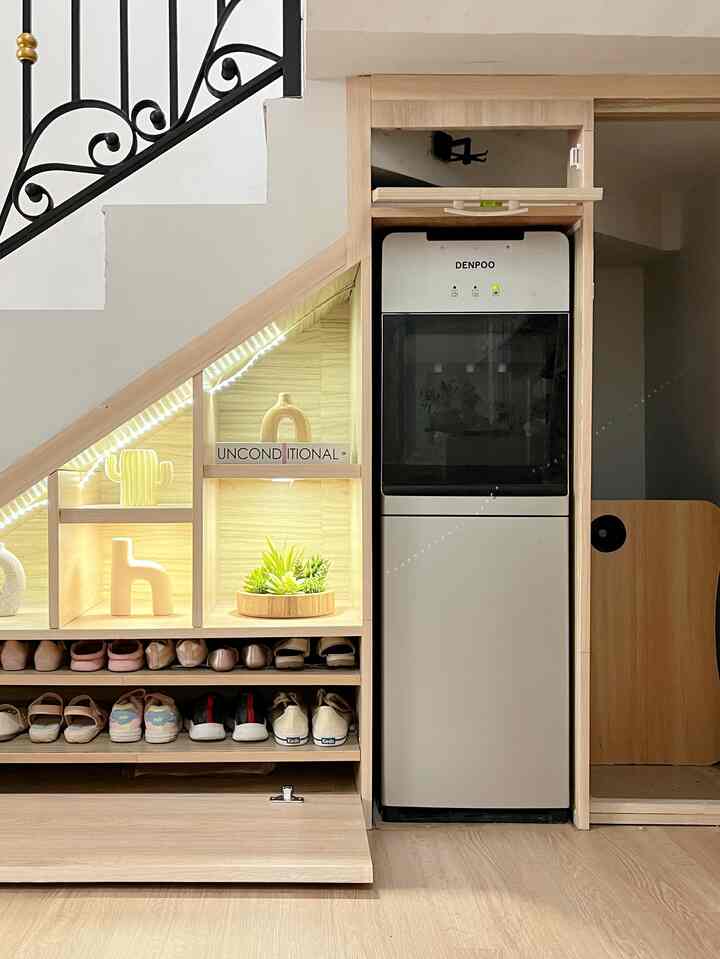 Light beige wood tone entrance space featuring built-in under-stair storage with shoes, clean and practical atmosphere