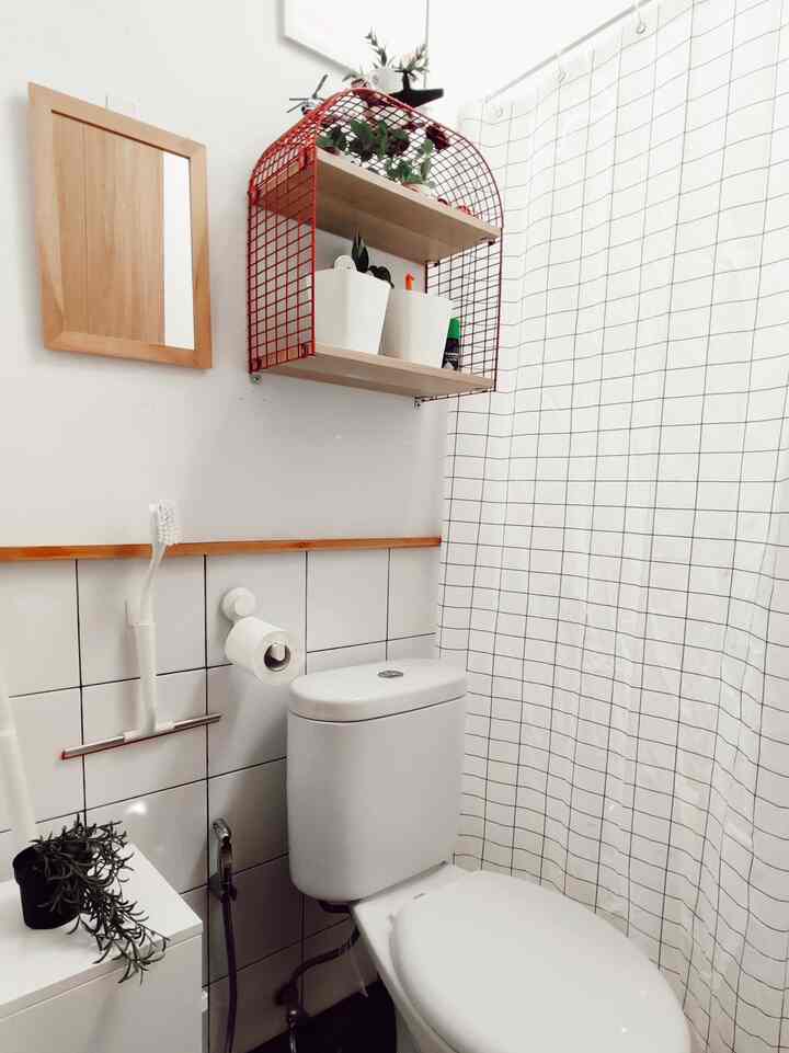 White and wood-toned small bathroom featuring shelves and checkered curtain with a clean, cozy feel