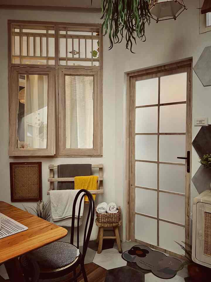 Soft brown and white toned kitchen featuring wooden dining table and chair, creating a warm and natural interior atmosphere