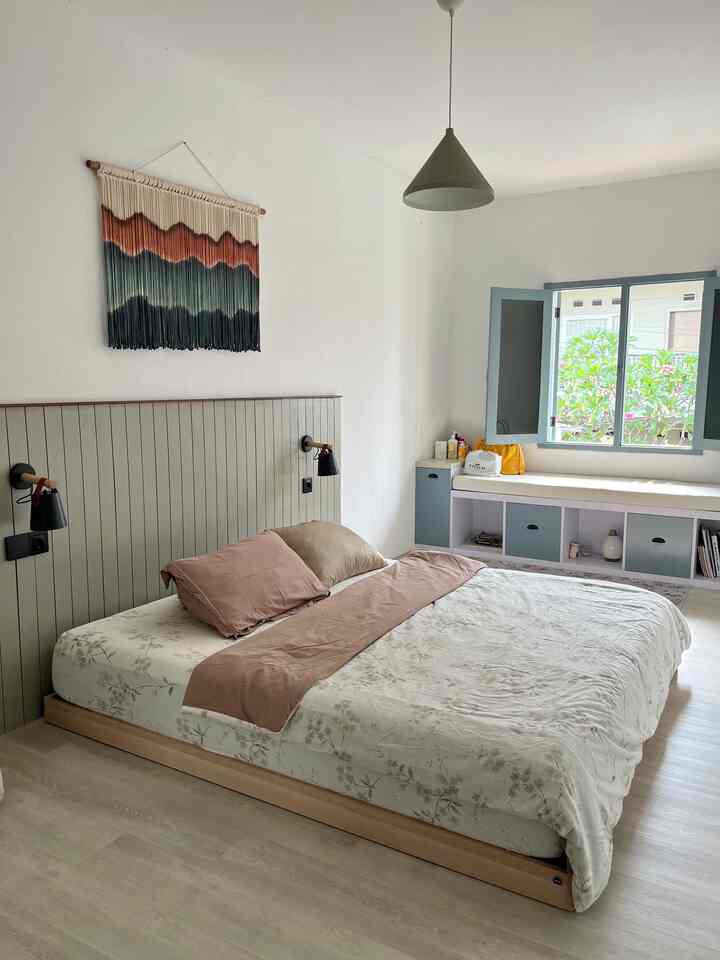White and brown toned bedroom featuring a king-size bed and wall sconces with a natural atmosphere