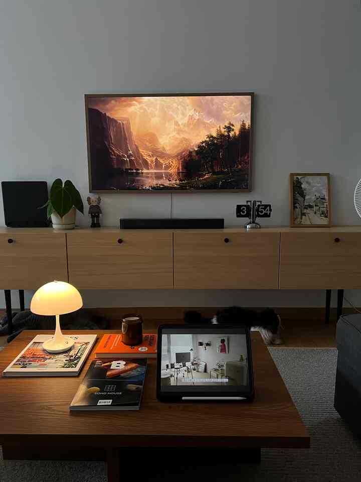 Modern natural living room dominated by warm brown wood furniture, featuring a coffee table and a large landscape artwork creating a cozy atmosphere