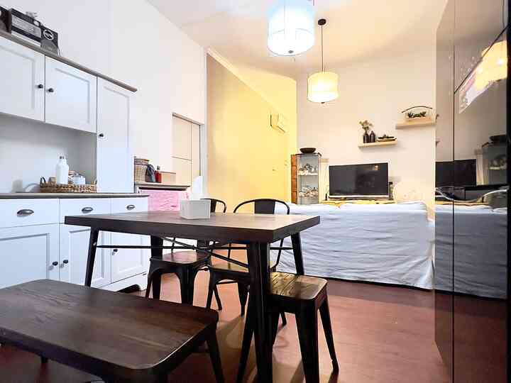 White and brown toned living and dining room for two, featuring modern dining table and sofa with a clean atmosphere