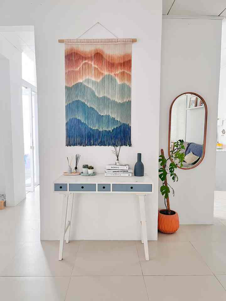 Natural toned living room featuring a medium-sized desk with multicolor wall décor creating a bright and tidy atmosphere
