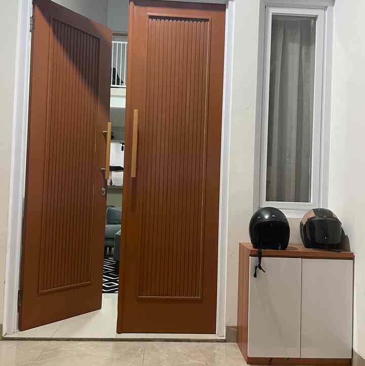 Clean entrance space with brown wooden doors and white shoe cabinet