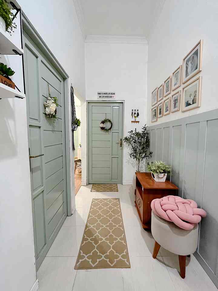 Natural tone entrance featuring mint-colored doors and paneling, brown wooden cabinet, and pink knot cushion with cozy atmosphere