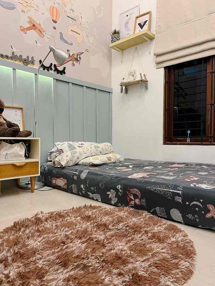 Beige and brown toned small bedroom featuring a low floor bed with a round brown carpet, creating a cozy atmosphere