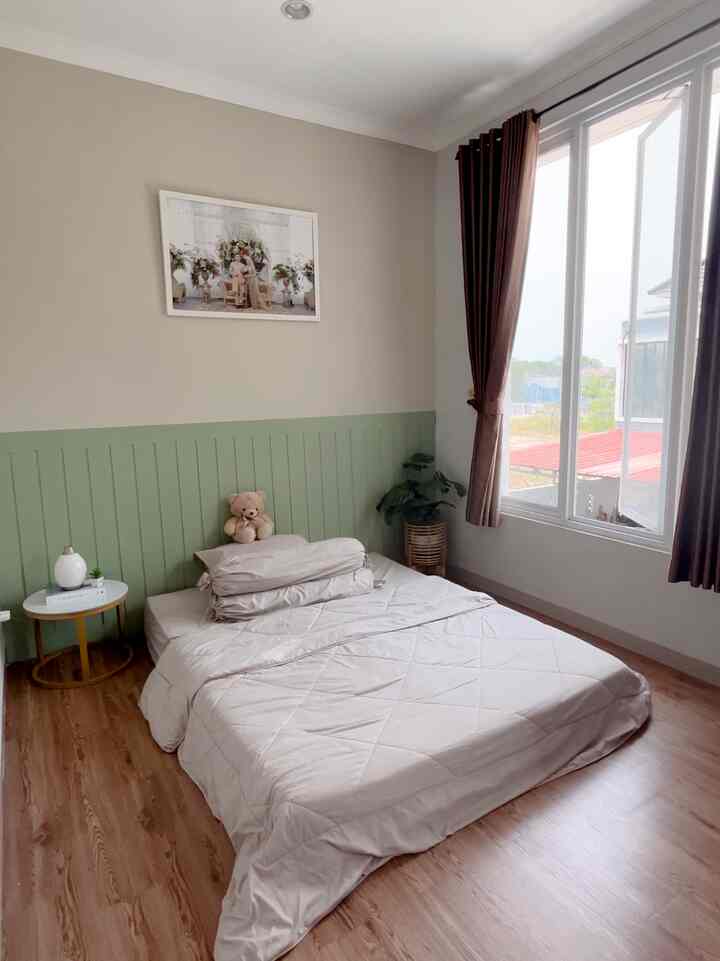 Cozy 6-tatami bedroom in beige and green tones featuring a bed, side table, curtains by large window, with natural ambiance