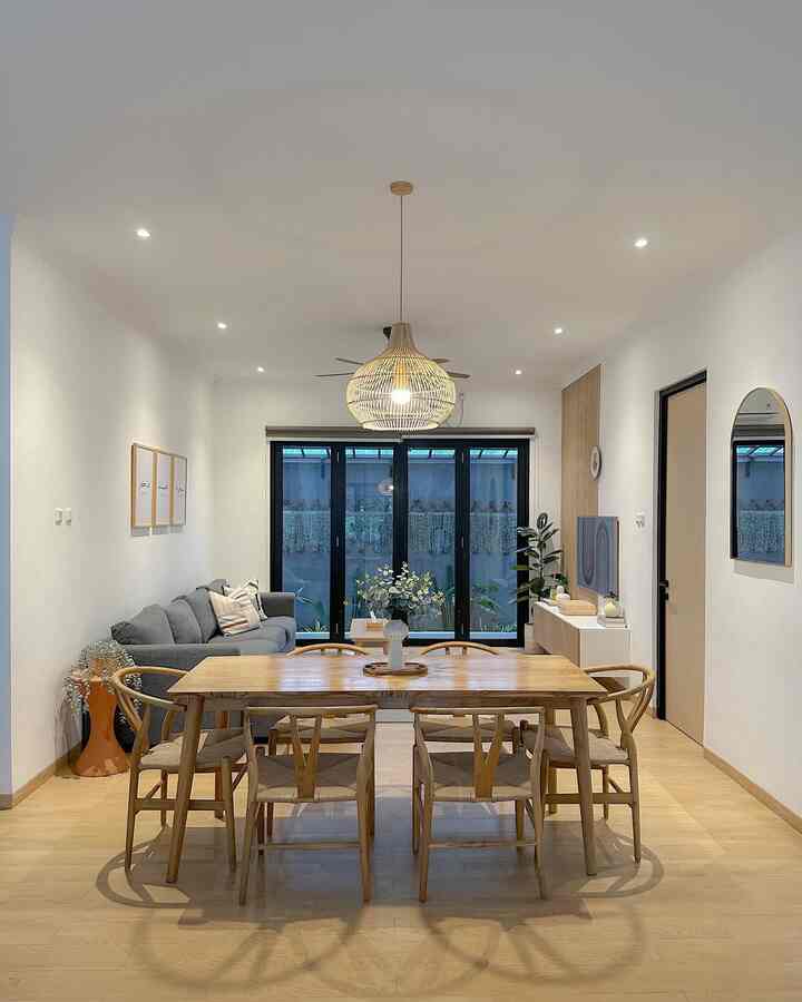 Modern dining room and living space with white walls and wood tone furniture