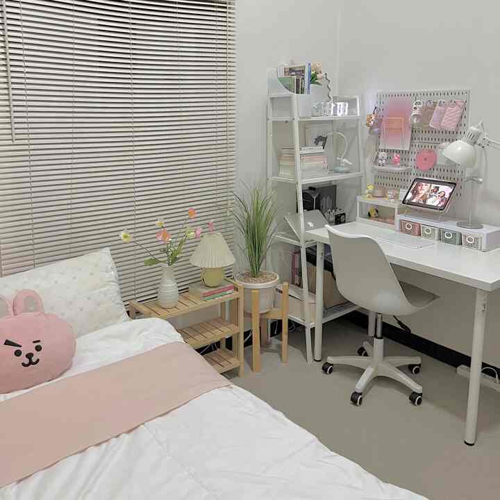A small single household room in white and beige tones, featuring a simple modern bed and home office desk creating a cozy atmosphere