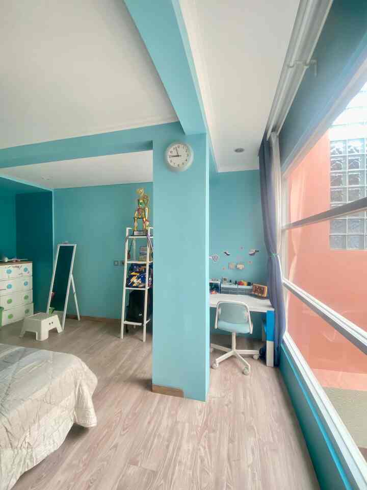 A 6-tatami size kids' bedroom with blue walls and large window, featuring a study desk and bookshelf in a bright child-friendly space