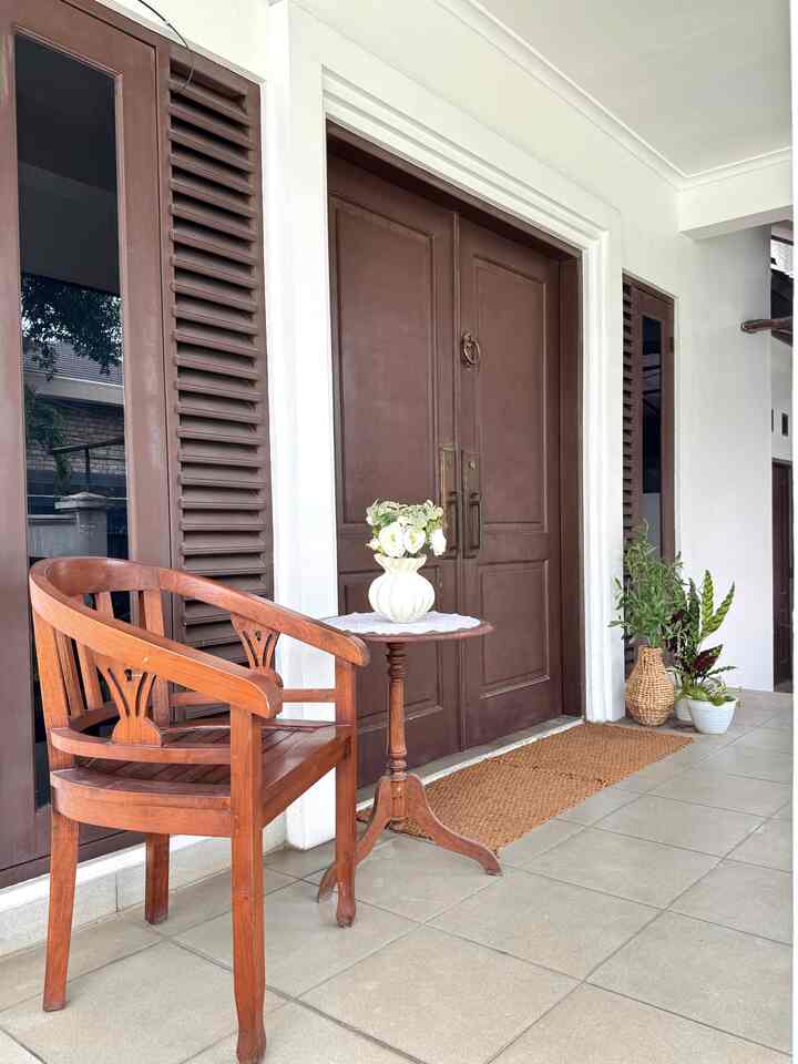 Brown-toned entrance space featuring a wooden chair and small table with a vase decorated in a natural atmosphere