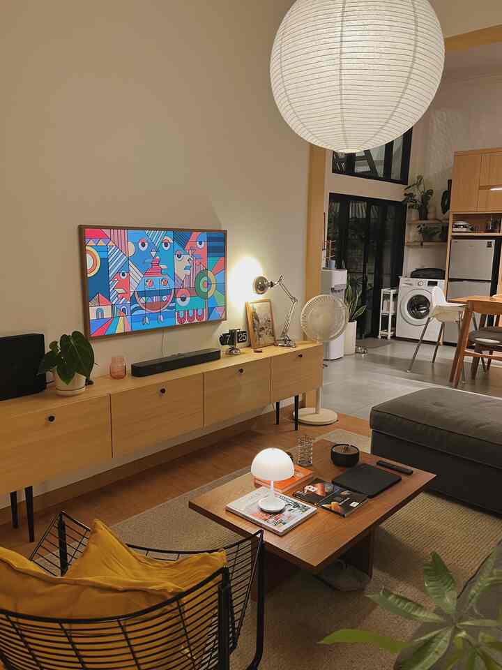 A modern and natural living room and kitchen connected, featuring white and wood tones