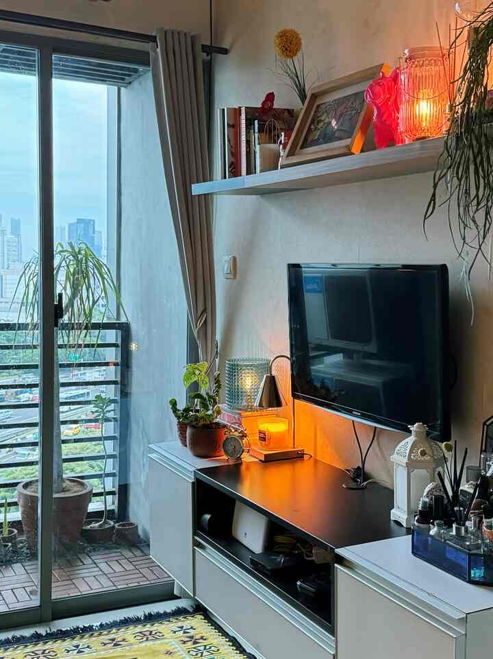 White and black living room featuring a balcony with natural light and warm candle lighting creating a cozy atmosphere