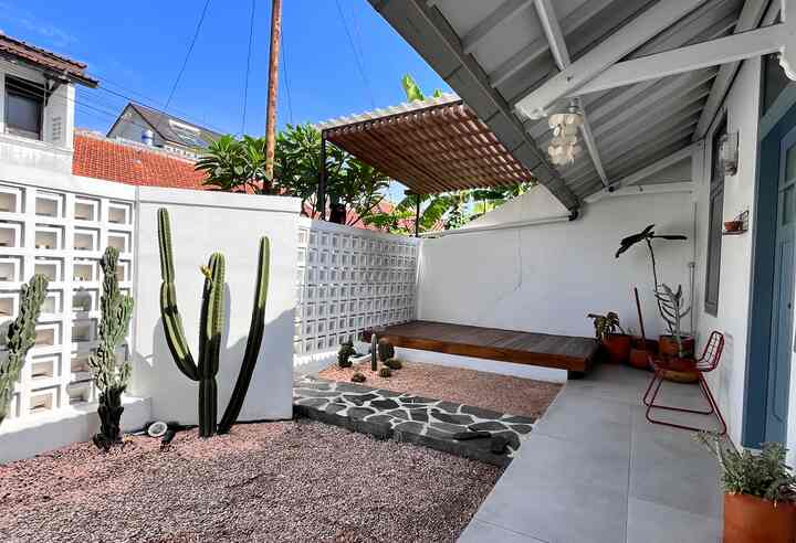 Natural modern outdoor terrace with white walls, orange gravel, and wooden deck