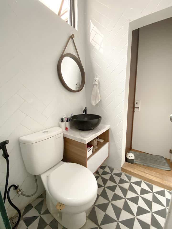 Black & white bathroom

Ini adalah kamar mandi yang terletak di dalam kamar anak, dengan akses langsung ke ruang tamu dan ruang makan. Karena terhubung dengan kedua ruangan tersebut, terdapat dua pintu untuk masuk ke dalam kamar mandi ini.

Untuk menyamarkan salah satu pintu yang mengarah langsung ke ruang makan, kami menciptakan sebuah pintu kamuflase yang terlihat seperti bagian dari dinding kayu atau pintu lemari.

Kamar mandi ini memiliki tema black & white, dengan menggunakan subway tiles putih untuk dinding dan shower serta wastafel berwarna hitam. Lantainya diberi keramik hitam dan putih untuk menambah kesan kontras yang menarik.

#bathroom
#kamarmandi
#inspirasikamarmandi
#homedecor
#toiletkering 
#homestagram 
#blackandwhite
#cerminbulat 