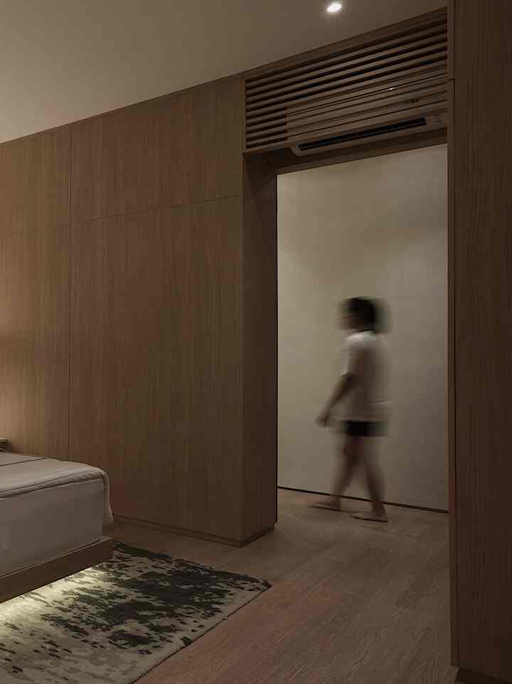 Natural wood tone and beige bedroom featuring a builtin closet and bed, with simple and modern atmosphere