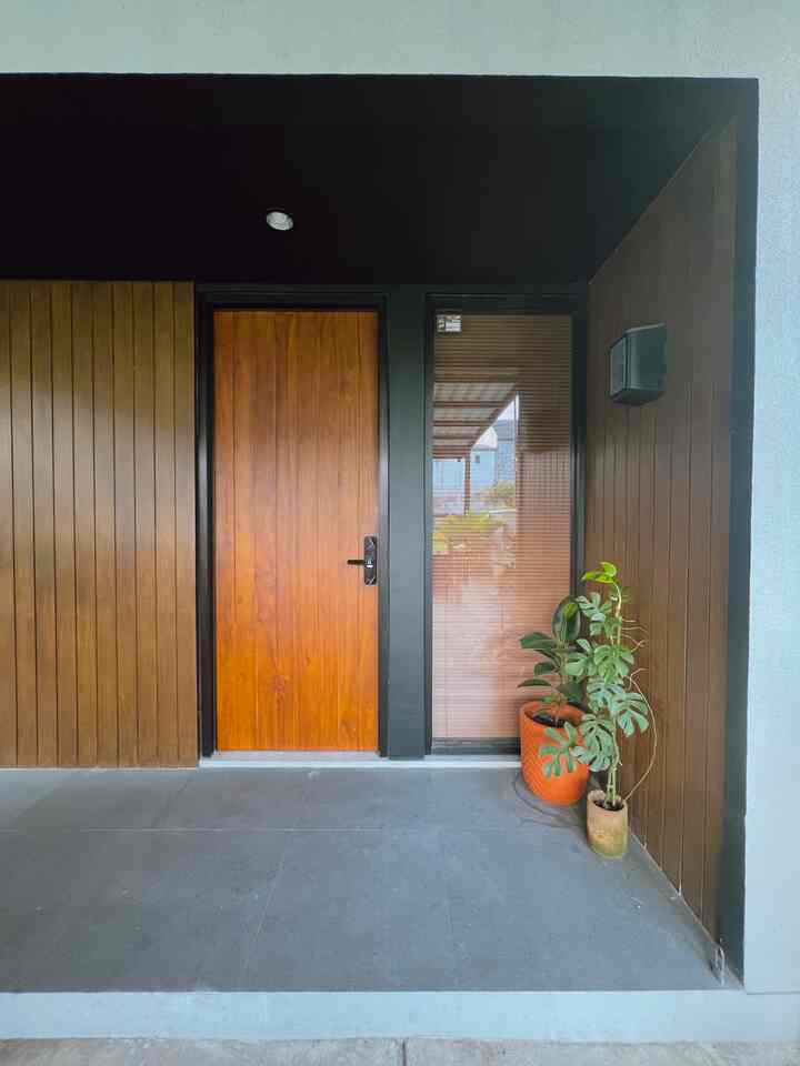 Modern entrance with wood tone featuring wooden door, blinds, and potted plants in a simple outdoor setting