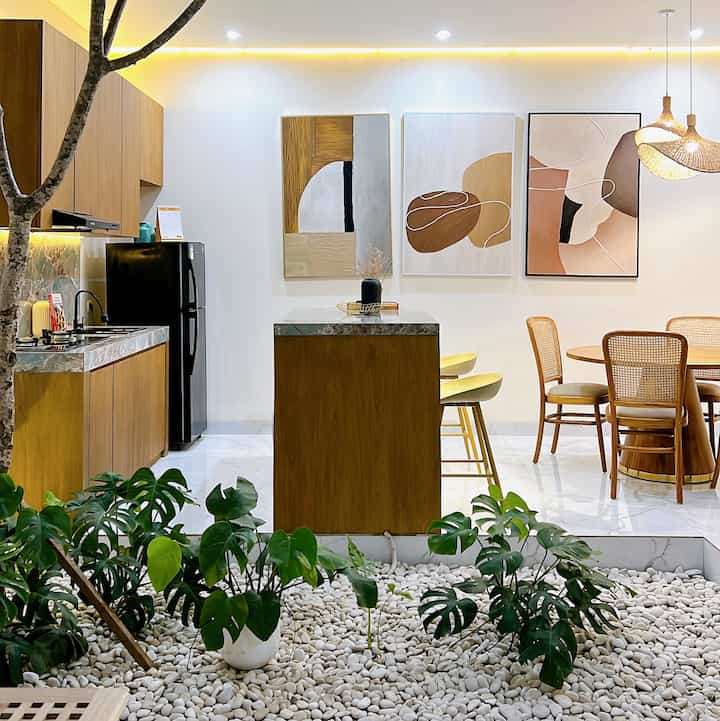Natural color dining room with white background, wood tone dining table and kitchen island
