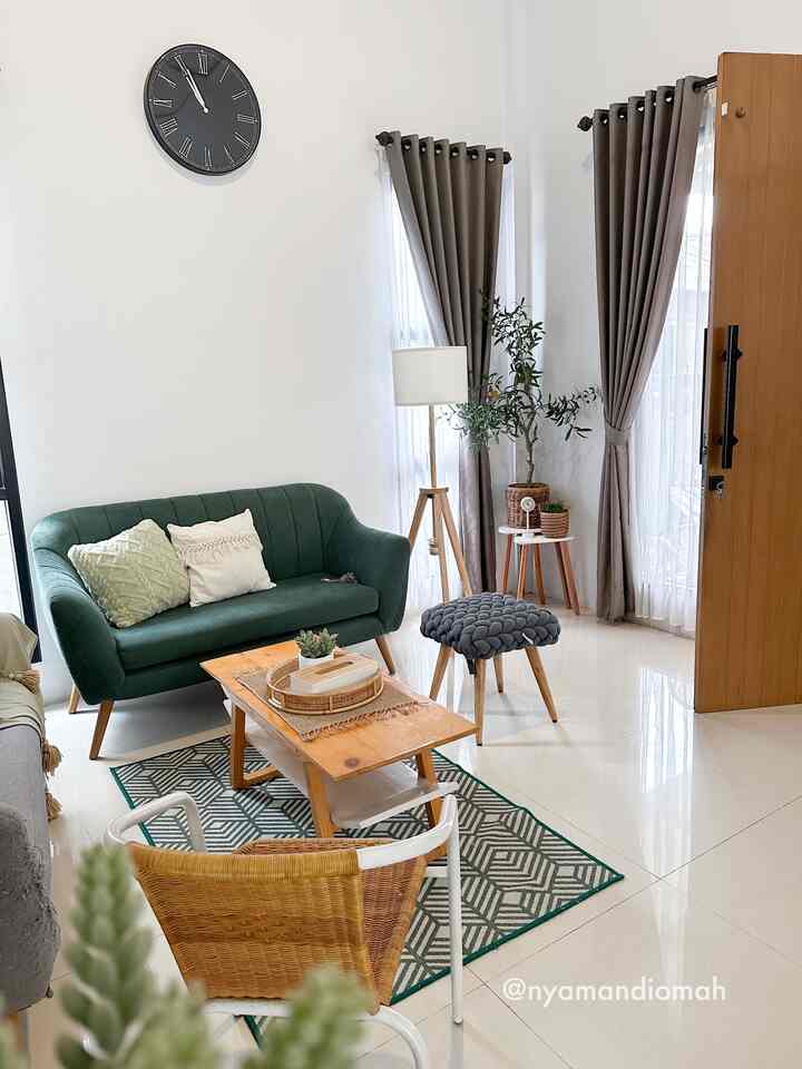 Bright Scandinavian living room with white walls and wood-tone furniture, featuring a green sofa and natural plants for a fresh atmosphere