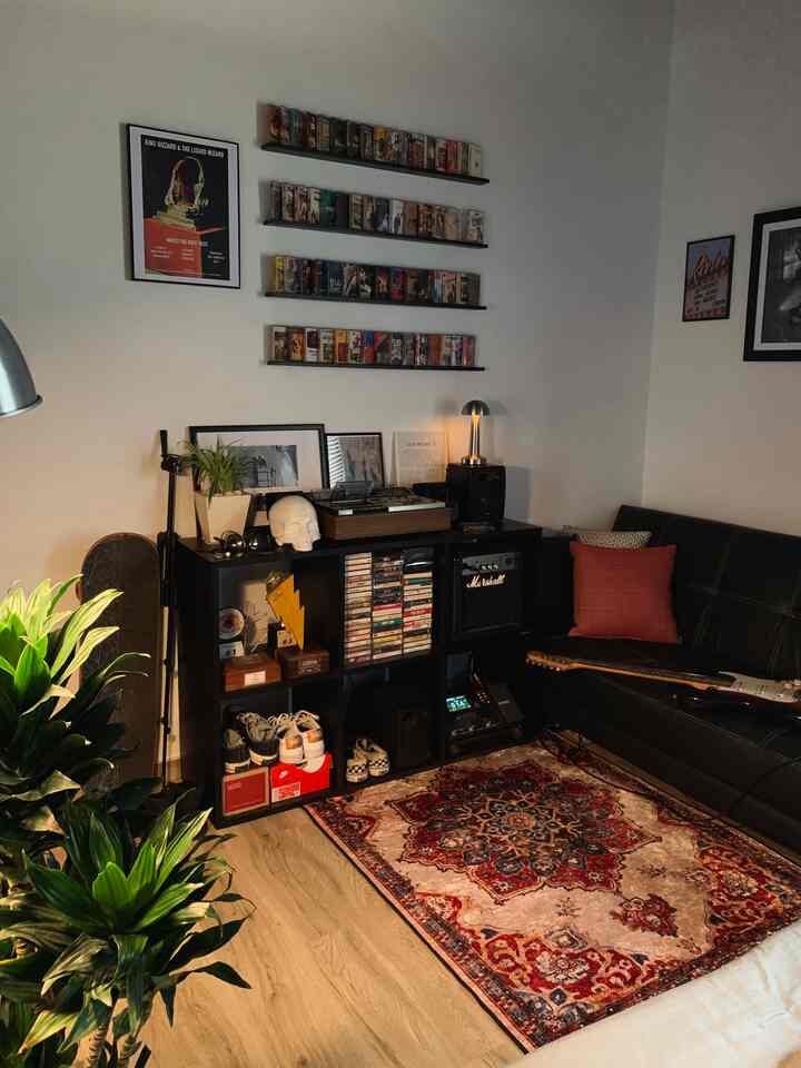 Dark black and brown toned living room featuring black sofa and music equipment in a vintage atmosphere