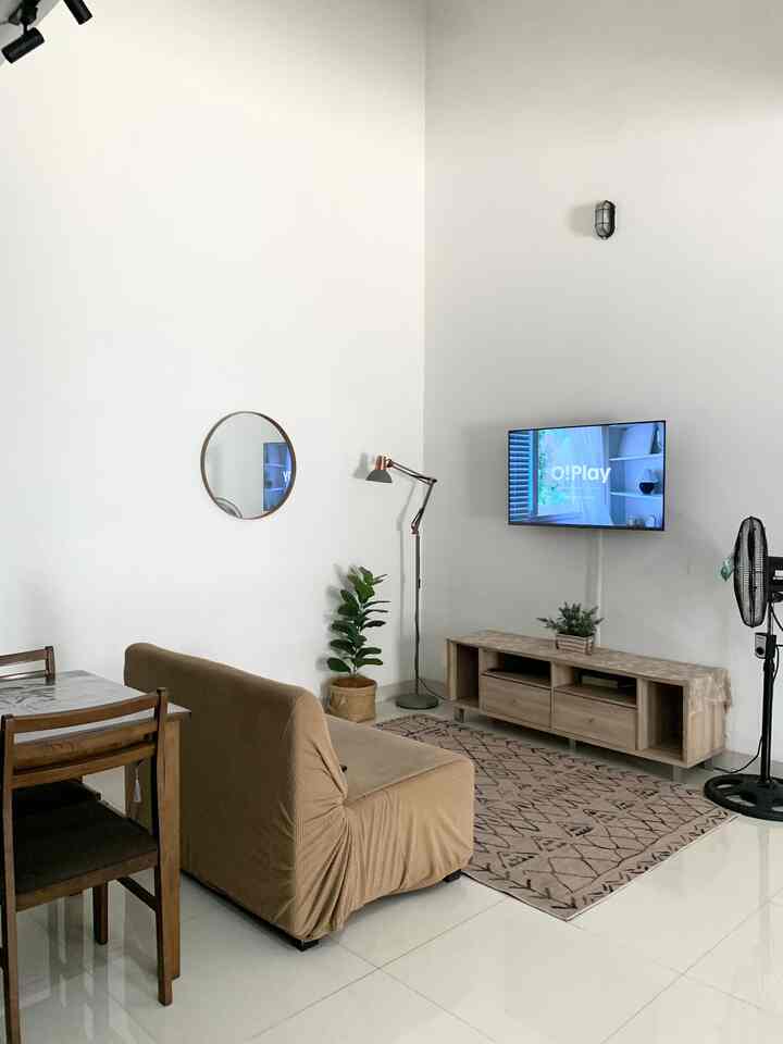 White and brown toned living room featuring sofa and TV stand with a simple and natural atmosphere