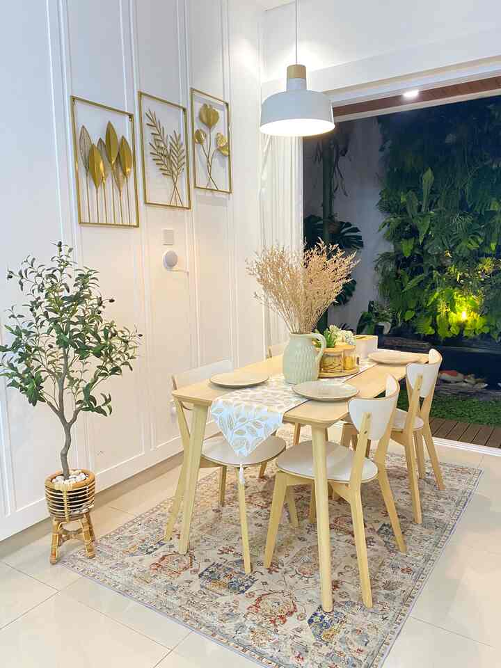Bright wood tone and white dining room featuring table, chairs, plants, and lighting in a natural setting