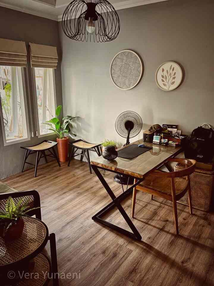 Gray-toned walls and wood-tone flooring in a natural home office featuring a wooden desk and rattan stools