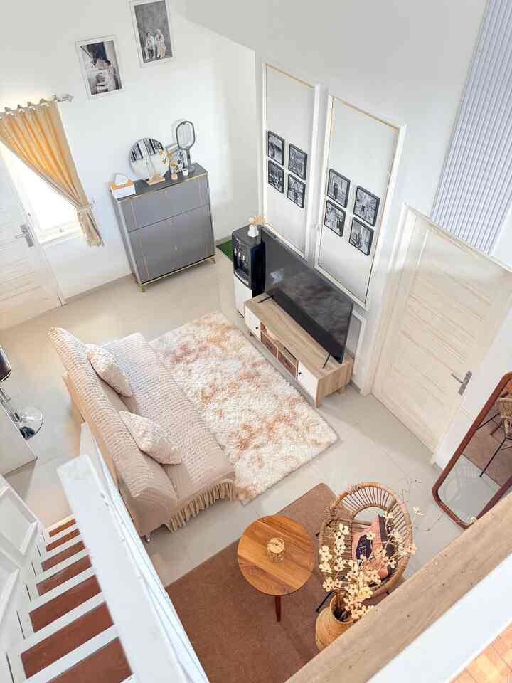 Natural tone living room with white walls, beige sofa, and a plush carpet arranged neatly