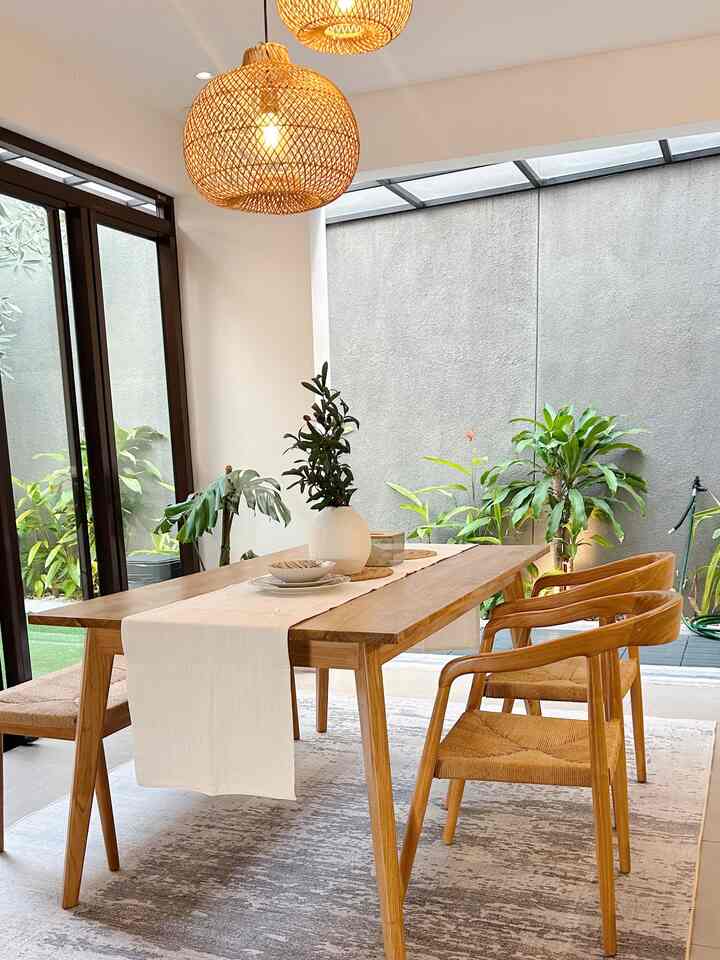 Natural wood-tone dining room featuring wooden table and chairs, carpet, and plants creating a cozy atmosphere