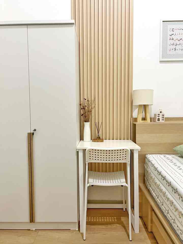 Natural tone compact kids' bedroom featuring a white desk, bed, and wardrobe arranged in a minimalistic space
