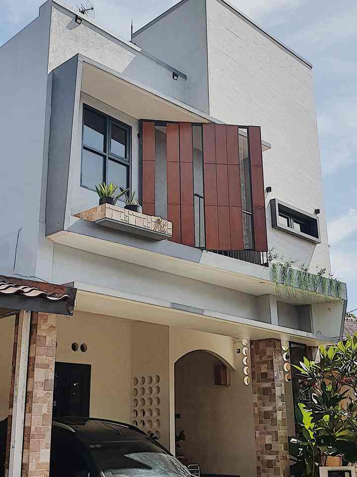 Modern house facade in white and brown tones with a unique angled structure and plant decorations