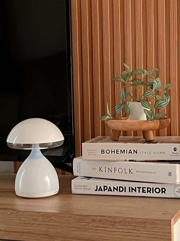 Modern interior featuring wood tones and white elements with a bookshelf and table lamp