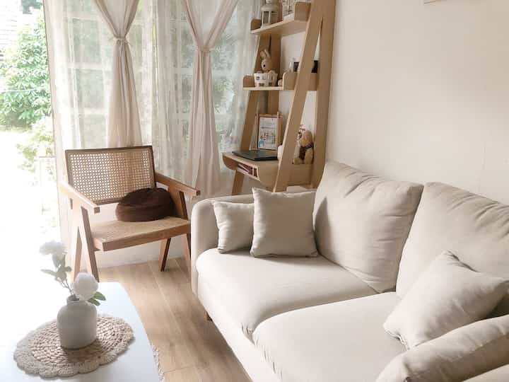 White and wood tone two-person living room featuring sofa and armchair in a natural modern style space