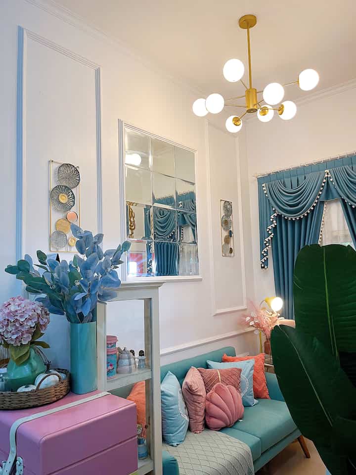 White and sky blue compact living room featuring pastel cushions and gold pendant lighting in a classic Scandinavian style