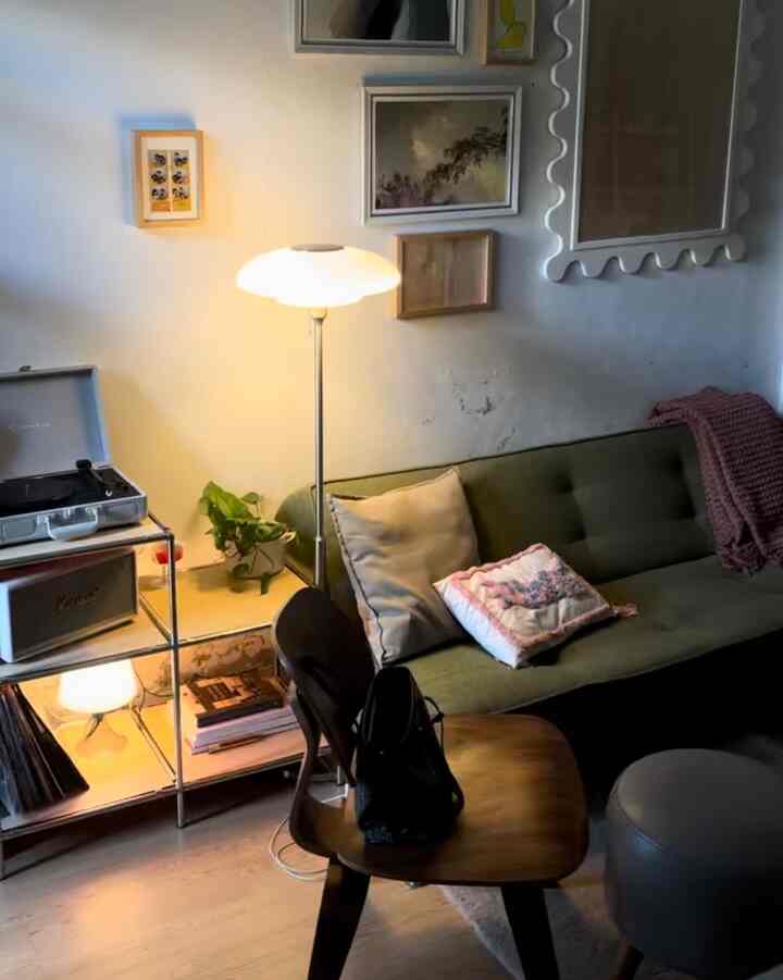 Warm wood-toned floor mid-century modern living room featuring olive green sofa and retro decor elements for a cozy atmosphere