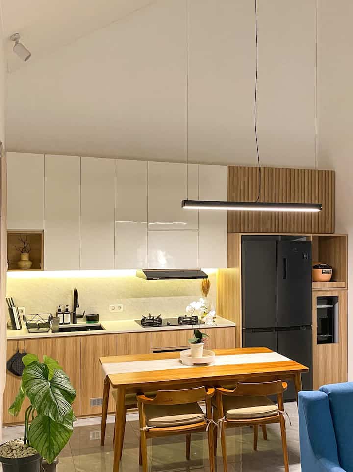 Beginilah suasana saat malam hari di area open space yang kami terapkan.
Kitchen Set, Dining Set juga Living Room menjadi satu ruangan yang cukup besar berukuran 6 x 4 m.
Terdapat lampu sorot di setiap sudut ruangan, led strip di kitchen set, lampu gantung pada dining set juga standing lamp pada living room membuat suasana malam terkesan lebih hangat.

Kami memilih japandi industrial kitchen set ini karena menyesuaikan dengan konsep rumah. Bentuknya yang linier dan compact membuat ruangan terkesan lebih rapih dan lega.
Pemilihan material hpl dengan warna putih & natural brown ini untuk memunculkan unsur japandi. Untuk kitchen appliances, kami memutuskan untuk konsisten memilih warna hitam atau paling tidak ada sedikit hitamnya, agar konsep japandi industrial bisa tetap terasa di kitchen set ini.

#MyDreamKitchen #IdeDekorDapur #DapurEstetik #JapandiIndustrial #Kitchensetinspo #homeinspo #inspirasidapur