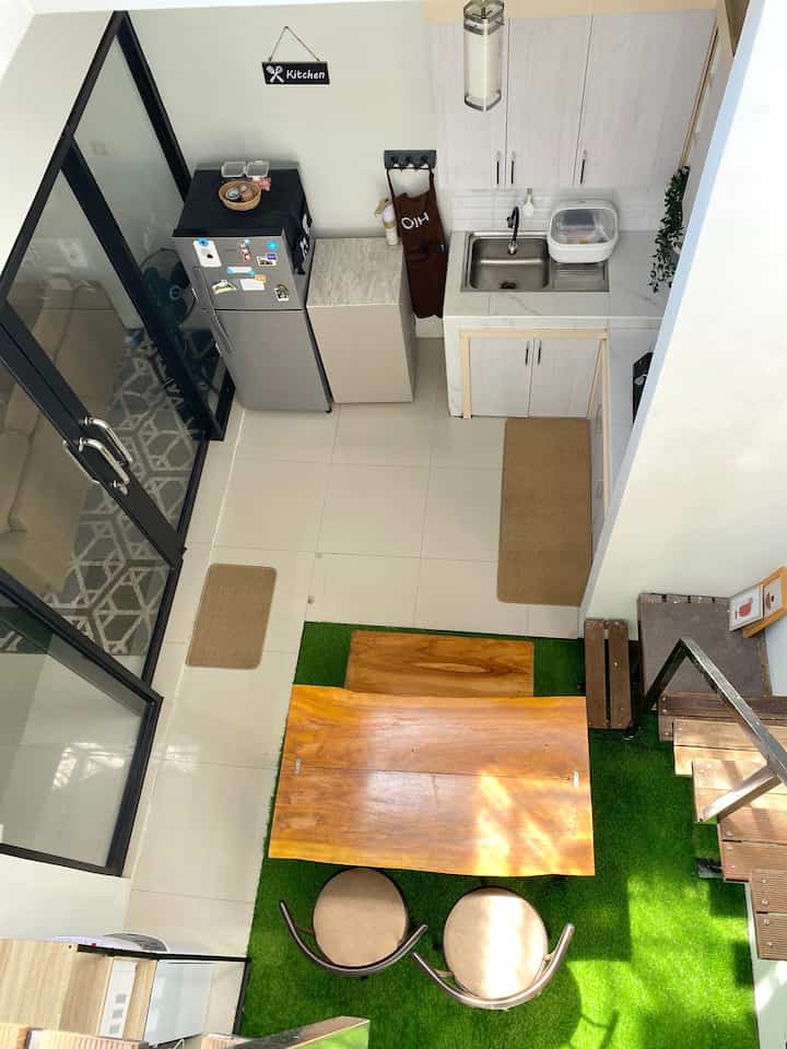 White and brown compact kitchen space featuring wooden dining table and chairs with clean minimal atmosphere