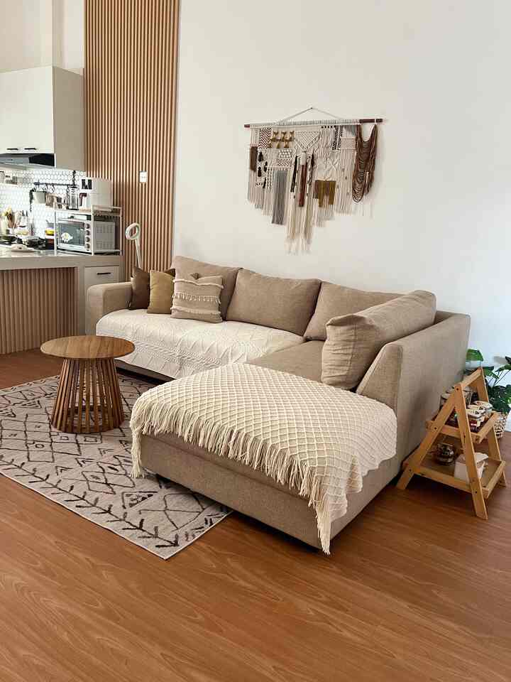Beige and wood tone living room featuring a beige sectional sofa and wooden side table with warm natural ambiance