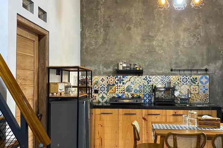 Natural wood tones and colorful tiled industrial style kitchen and dining room space