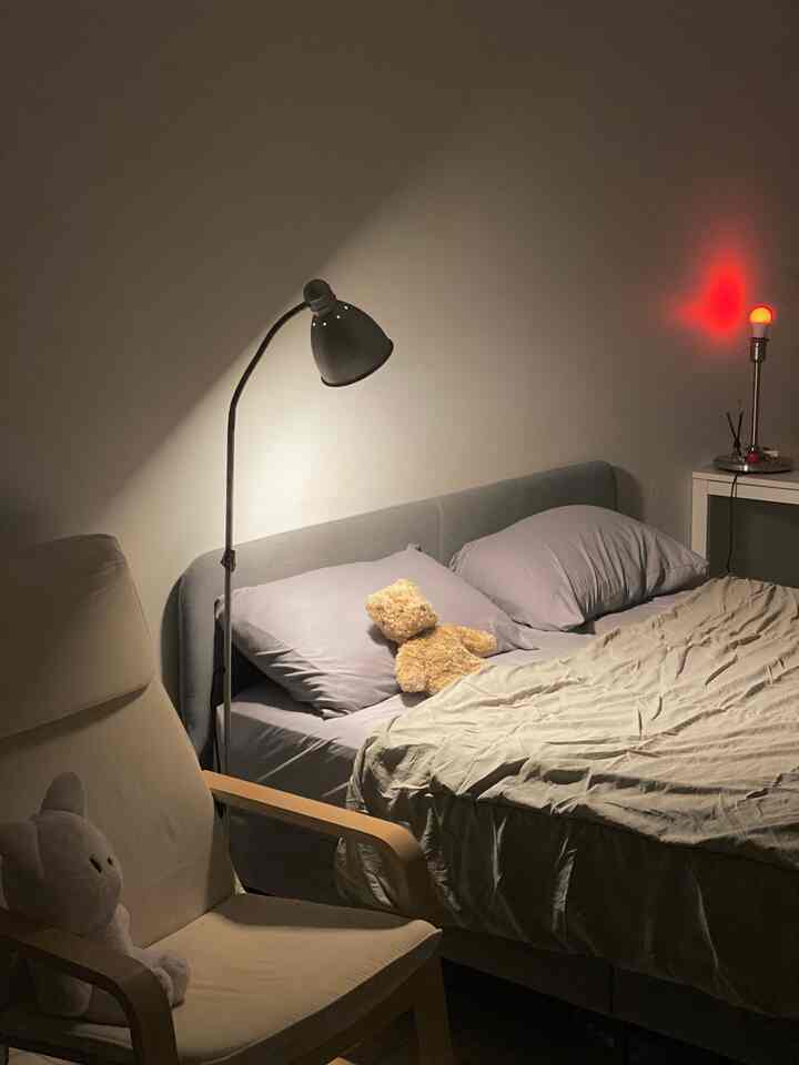 Beige and gray toned bedroom featuring a bed and armchair with cozy atmosphere