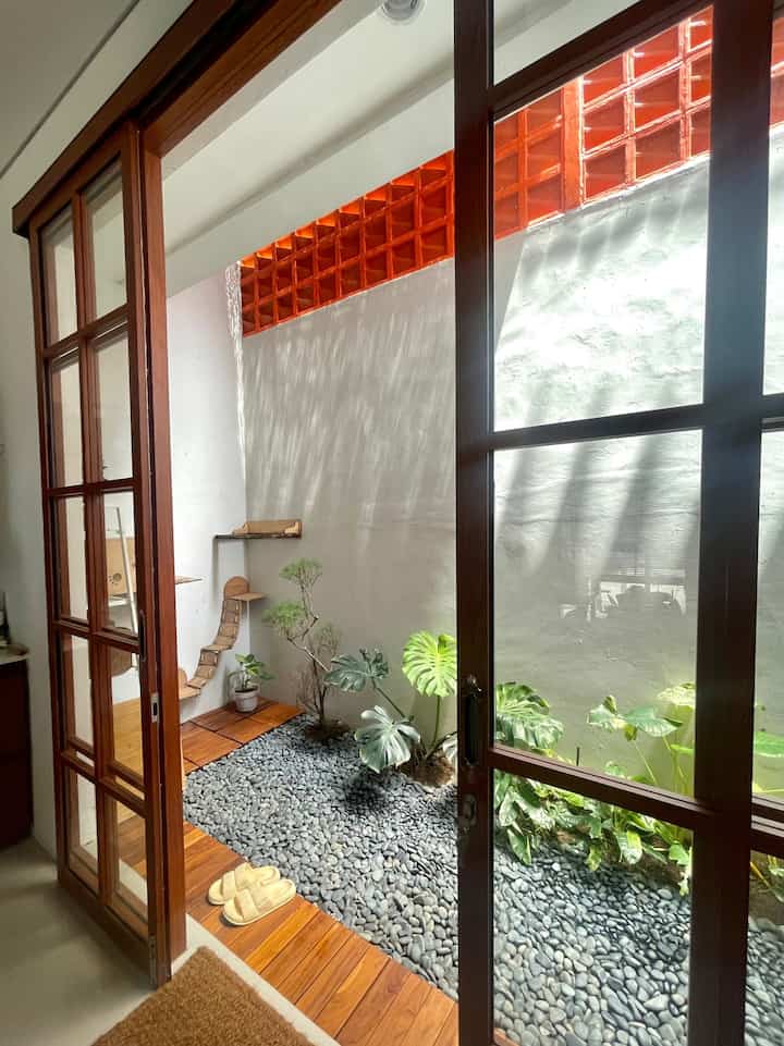 Taman / Backyard
Taman kecil berukuran 5 meter x 1,5 meter ini merupakan sisaan tanah belakang rumah bawaan developer yg awalnya tanpa pintu. Kemudian kami putuskan memasang pintu aluminium kaca bermotif kayu dan sliding sebagai pemisah area luar dengan dapur dan ruang makan. Selain memanfaatkannya sebagai ruang terbuka untuk tanaman dan resapan air hujan, kami menambahkan dekorasi playground untuk kucing disisi kiri dan sebagai ruang cuci jemur di di sisi kanan yg kami beri pembatas roaster. Tujuannya supaya tidak terekspos langsung dari ruang makan. Atasnya dibiarkan terbuka supaya sirkulasi udara mengalir. Lalu menambahkan roaster lagi diatas dinding dan paranet setengah dari atap taman untuk menjaga tanaman tetap teduh, tidak terkena terik matahari langsung namun masih mendapatkan cahaya dan udara yg cukup.. kadang sya juga menaruh kursi bersi dan bersantai menikmati hijau-hijau bersama lulu & popo 🐾

#backyard #tamanbelakangrumah #innercourtyard #outdoorinspo #tanamanhijau
