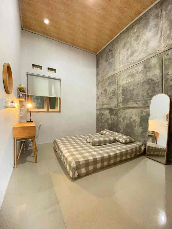 Natural color bedroom featuring a wooden desk and checkered bedding, creating a cozy and bright atmosphere