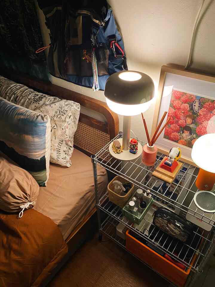 Cozy bedroom with warm light brown tones featuring a wooden bed and metal shelving with bedside lamps
