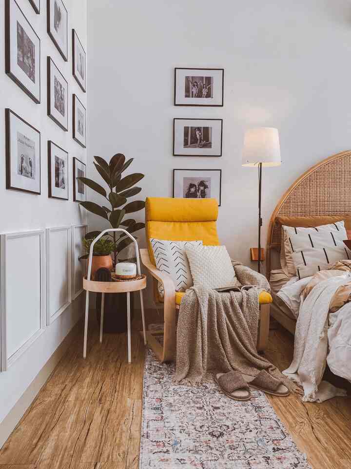 Natural-style bedroom featuring bright yellow armchair, wood flooring, and rattan bed headboard with cozy and warm atmosphere